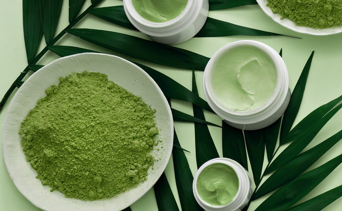 matcha in a bowl next to three matcha beauty creams