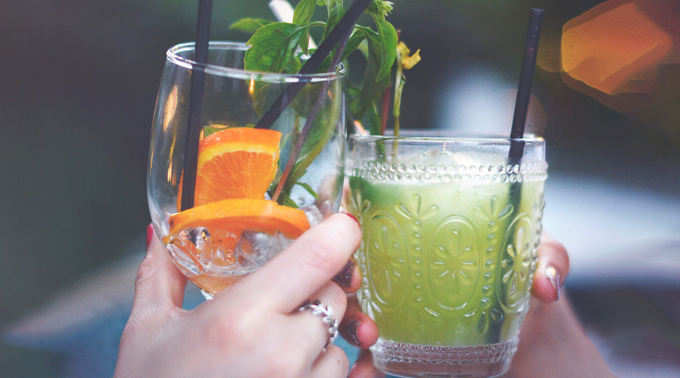 2 hands holding cocktail glasses reflective of 2020's beverage trends.