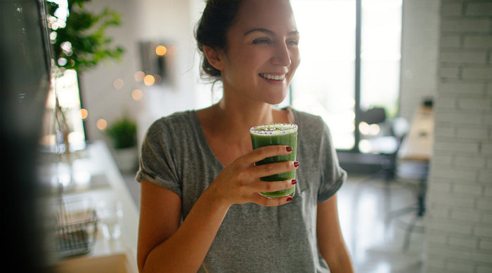 A woman drinking a matcha smoothie