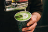 A barista pours milk into matcha green tea healthy beverage