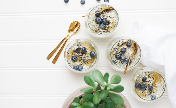 matcha green tea overnight oats next to a golden spoon and jade plant on a white surface