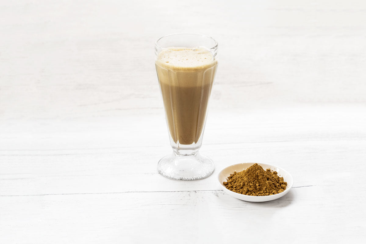 a hojicha latte next to a bowl of hojicha powder