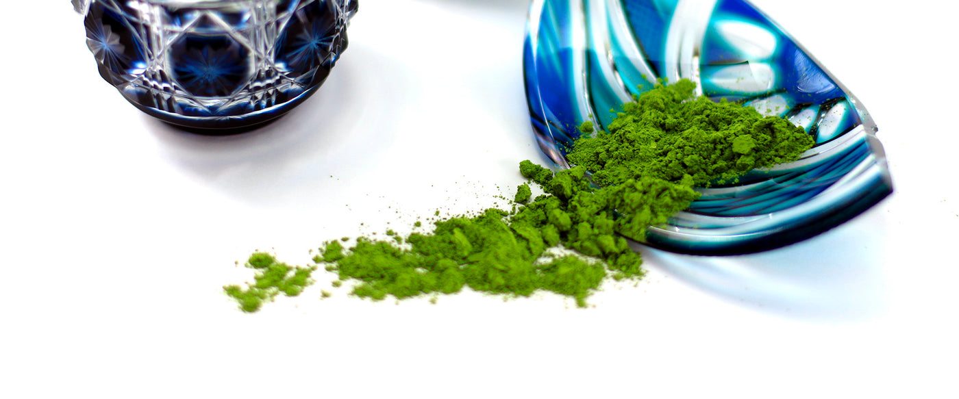 Matcha green tea on a white table with 2 blue crystal bowls